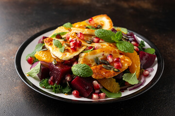 Fried Halloumi Cheese salad with beetroot, orange, pomegranate and pumpkin seeds, red onion, green vegetables. healthy food