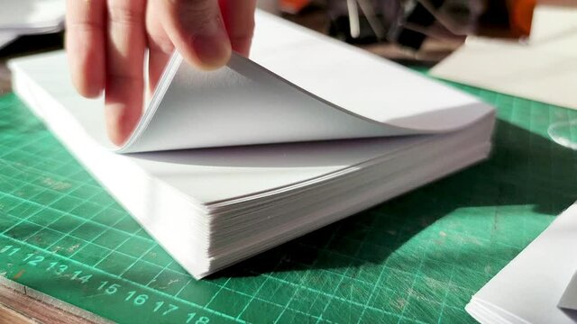 Office paper. Female hand close up flips through sheets of office paper. Crafting a Handmade Notebook