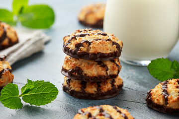 Coconut macaroons cookies with drizzle of chocolate served with glass of milk. Gluten free