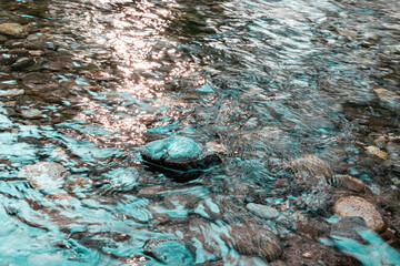Pebbles in the stream water running, spring, nature wallpaper background concept