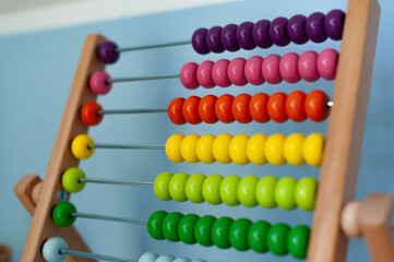 Multi-colored designer background. Calculating Colorful wooden rainbow abacus for number calculation. Close up wooden abacus on white background. Mathematics learning concept. Rainbow colors