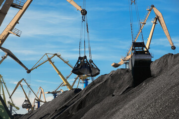Industrial buckets of portal cranes and coal piles