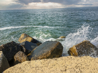 Fototapeta na wymiar water splash at a rock on the beach in summer
