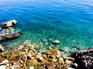 stones at the beach with clear water in summer