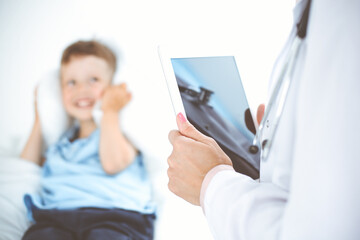 Happy smiling male kid-patient at usual medical inspection. Doctor and young boy in the clinic. Medicine concepts