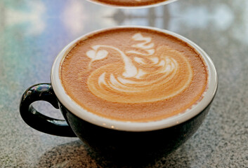 Cup of cappuccino coffee with latte art isolated on the table