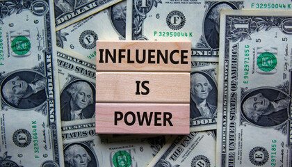 Influence is power symbol. Wooden blocks with words 'Influence is power'. Beautiful background from dollar bills. Business, influence is power concept, copy space.