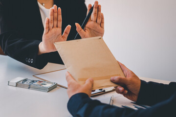 Businesswoman accountant is rejecting money in white envelope offered by his partner in the dark -...