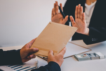 Businesswoman accountant is rejecting money in white envelope offered by his partner in the dark -...