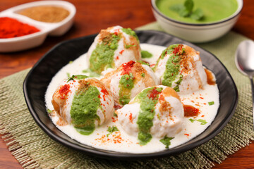Indian street food Dahi vada Dahi Bhalla with green chutney, tamarind chutney chaat appetizer thayir vadai curd vada soaked in yogurt. North Indian snack Delhi Mumbai India, sri Lanka ,Pakistani food