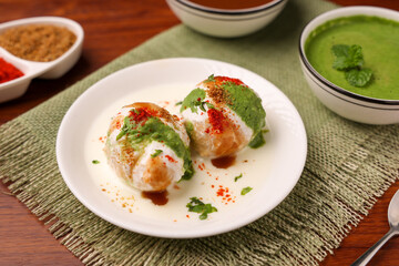 Indian street food Dahi vada Dahi Bhalla with green chutney, tamarind chutney chaat appetizer thayir vadai curd vada soaked in yogurt. North Indian snack Delhi Mumbai India, sri Lanka ,Pakistani food
