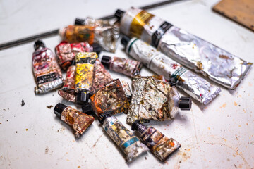 Old oil paint kit with attaché case. Various dirty oil paint tubes in a briefcase. Tidying, neatening and setting an used oil paint set during a painting workshop activity in a studio