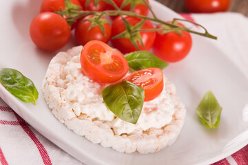 Rice cakes with milk flakes and tomato.