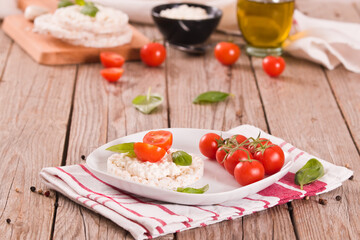 Rice cakes with milk flakes and tomato.