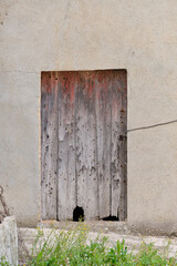 Facade of an old abandoned house with an old and rotten door.
