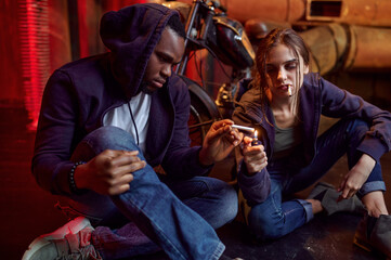 Drug addict man and woman smokes a cigarette