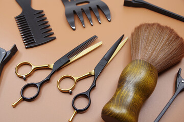 Professional hairdressers tools isolated on brown background. Hairdressers scissor, comb and hairpins.	