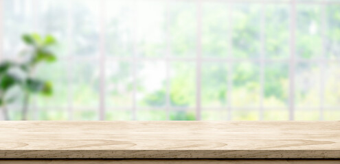 wooden table background with blur window see through garden at home.Mockup banner space for product...