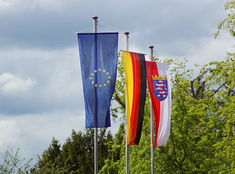 Flagge von der Europäischen Union, Deutschland und dem Bundesland Hessen, die an einer Fahnenstange hängen