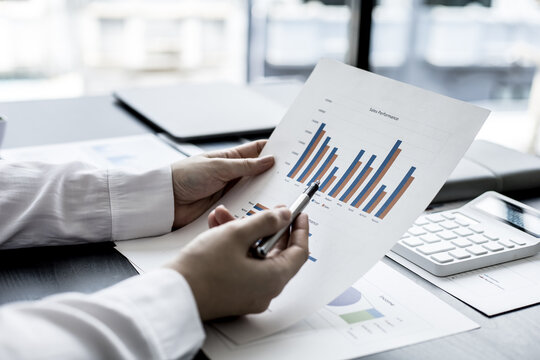The sales manager pointing at the sales document, she is reviewing the monthly sales report of the salesperson to summarize and plan the next month's sales management. Sales management concept.