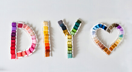 Word DIY world made of colorful bobbins, treads. Do it yourself concept. Sewing, hobby