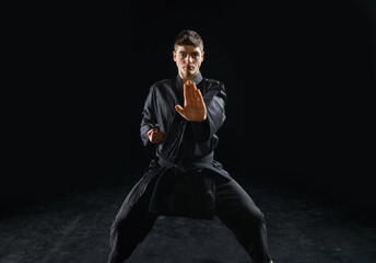Fototapeta na wymiar Male karateka, fighter practice in black kimono