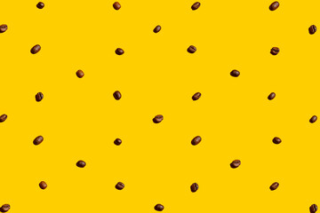 Coffee beans organized and forming a texture over yellow background. Flat lay photo.