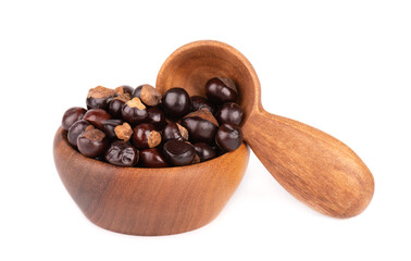 Guarana seed in wooden bowl and spoon, isolated on white background. Dietary supplement guarana, caffeine cource for energy drinks.