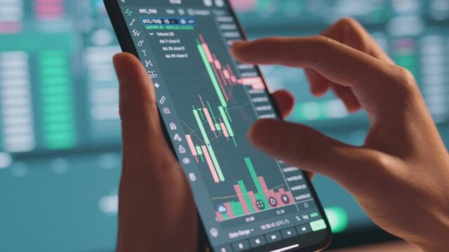 Closeup - Woman is checking Bitcoin price chart on digital exchange on smartphone, cryptocurrency future price action prediction.