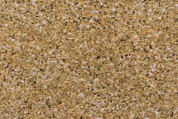 Fondo o textura de una pared de color amarillo con pequeñas piedras incrustadas