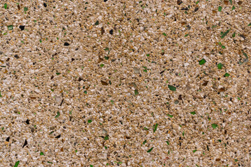 Fondo o textura de una pared de color amarillo con pequeñas piedras incrustadas