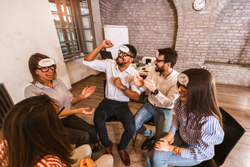 Business team having fun at corporate training, funny teambuilding activity, playing game guess who in the office.