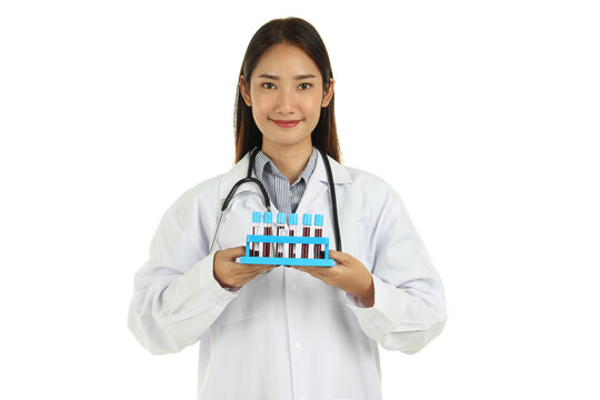 Portrait Of Smiling Young Beautiful Asian Female Medical Doctor In Lab Coat With Stethoscope, Holding Rack Of Blood Test Tube Samples Isolated On White Background.