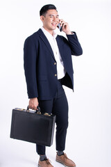 Asian 20s handsome young business man wearing formal suit, talking on mobile phone for...