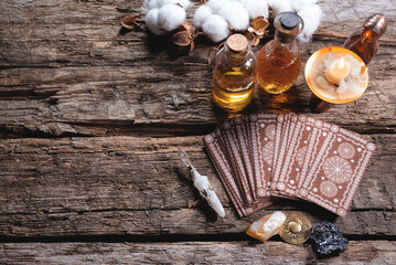 Tarot cards and magic potions on the wooden table background. Future reading concept.