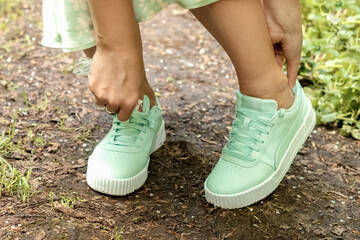 Woman adjust sneakers when they rub her feet