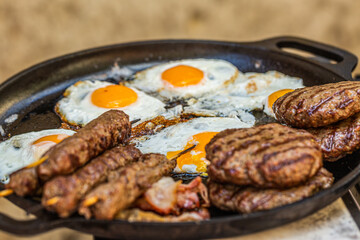 Prepared meat cutlet and fried egg for burger on pan, closeup