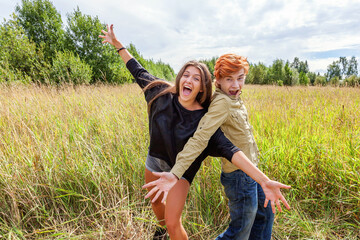 Summer holidays vacation happy people concept. Loving couple having fun together in nature outdoors. Happy young man dancing hugging with his girlfriend. Happy loving couple outdoor at summertime.