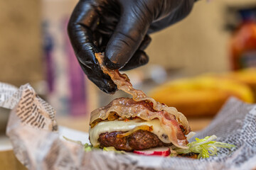 Chef prepares fresh delicious burger with ingredients. Closeup. Fast food