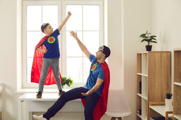 You can fly, believe in yourself. Happy active superhero kid ready to reach top success. Funny super hero dad and child playing at home. Confidence, fun childhood, future aspiration, challenge concept