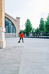 Caucasian boy playing with roller skates in the park.