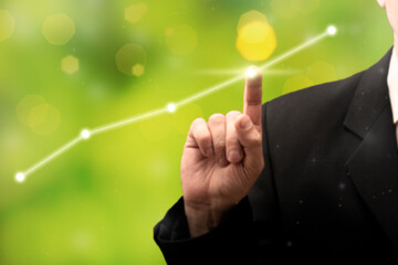 Businessman pointing graph future growth plan against green background. Business development to success and growing growth concept. Start-up project growth.
