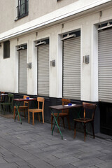 tische und stühle eines cafés stehen an der hauswand