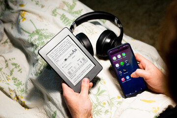 Home living lifestyle with modern electronic gadgets (ebook, headphones,smartphone). Man with...