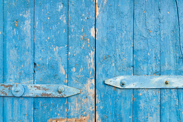 Wooden background. Old blue shabby wooden door. Torn up dilapidated boards. Natural creative texture for editing and design.