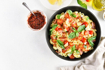 Tomato and bacon pasta with parmesan cheese and basil leaves