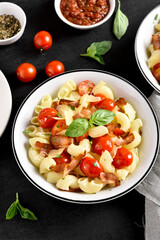 Pasta with bacon, tomato, parmesan cheese and basil leaves