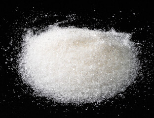 Obraz na płótnie Canvas handful of white sugar from sugar beet on black