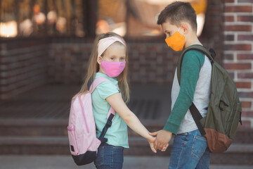 Little boy and girl in cotton mask at school ready to study in new normal