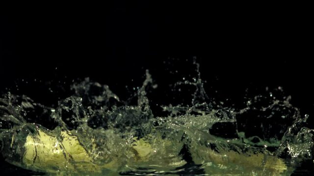 Super slow motion the cabbage pieces fall into the ode with the spray. On a black background. Filmed at 1000 fps.